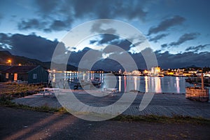 Scandinavian house and mirror lake with view to city and sea in the Norway at summer at sunset