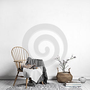 Scandinavian interior design style, wooden chair,books and rattan basket in farmhouse entryway or cozy living room.