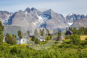 Scandinavian landscape with colorful wooden houses and a glacier