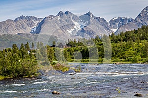 Scandinavian landscape with rapids in a river and a glacier in
