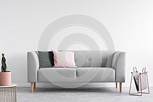 Scandinavian minimal design with grey sofa, real photo with copy space on the wall