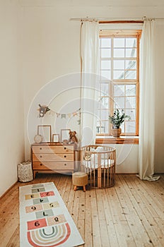 Scandinavian style children`s room interior. A cozy oval baby bed cradle