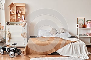 Scandinavian style white interior children's room, bedroom, nursery. Baby cot with canopy. Wooden shelves and toys