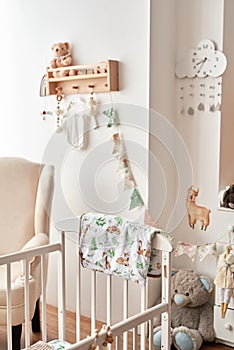 Scandinavian style white interior children's room, bedroom, nursery. Baby cot with canopy. Wooden shelves and toys