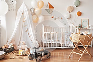 Scandinavian style white interior children`s room, bedroom, nursery. Baby cot with canopy. Wooden shelves and toys. Canopy tent,