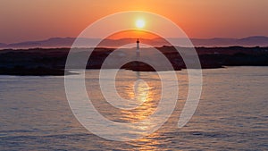 Scandinavian sunset over the sea with a lighthouse in the background