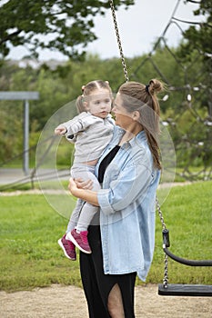 scandinavian woman with child in her arms in the park