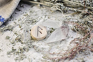 Scandinavian wooden rune Ansuz, As , Oss on a rough linen cloth with amethyst crystalline, rock crystal and dried wormwood photo