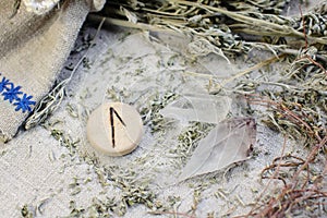 Scandinavian wooden rune Laguz, Lagu on a rough linen cloth with amethyst crystalline, rock crystal and dried wormwood