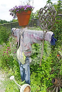 Scarecrow with old clothes and a carpet beater