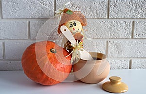 A scarecrow with a wooden spoon,a clay pot and a pumpkin on a white background.Halloween and Thanksgiving Day Concept