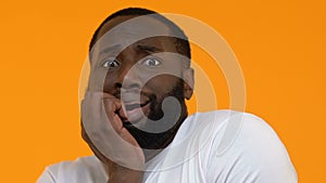 Scared african man on bright background, frightened person, phobia, anxiety