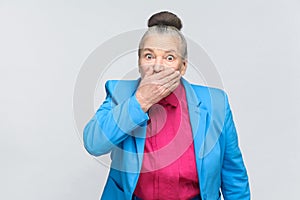 Scared aged woman closed mouth and have big eyes