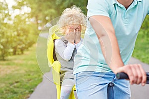 Scared baby girl in a bike seat on a bicycle