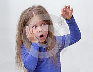 Scared child with holding piece of hair