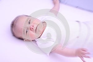 Scared crying baby, alone, in his crib