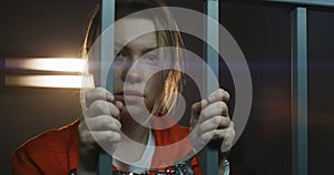 Scared female prisoner in handcuffs looks at camera