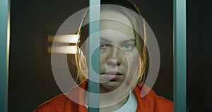 Scared female prisoner in handcuffs looks at camera