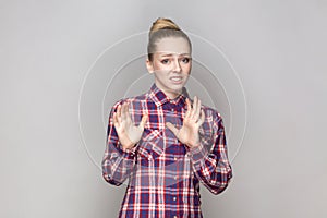 Scared frighten beautiful woman standing looking at camera, showing stop signs, being afraid.