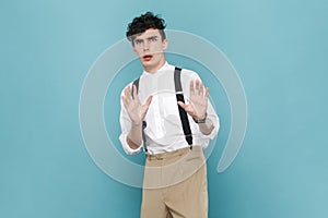 Scared frighten man trying to protect himself from danger, showing stop gesture with palms.