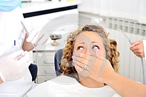 Scared girl at Dentist's teeth checkup photo