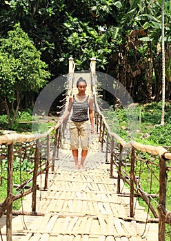 Scared girl on traditional bridge over river photo