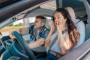 Scared instructor screaming sitting in the car and taking exam in young woman. Traffic accident. Driving test, driver