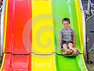 Scared little boy on slippery slide