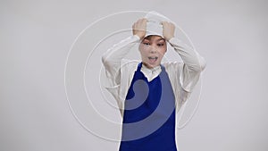 Scared little chef screaming holding head in hands posing at white background. Portrait of frightened newbie cook making