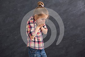 Scared little girl covering mouth with hands