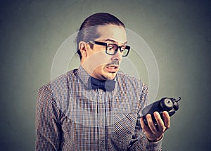 Scared man looking at alarm clock