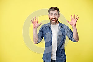 Scared man with raised his hands up and shouting sees something in front