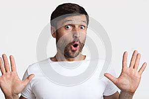 Scared Man Showing His Hands Looking At Camera, White Background