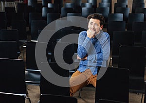 Scared man sitting in conference hall
