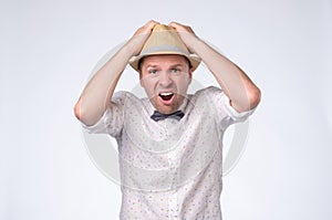 Scared man in summer hat shouting being stressed.