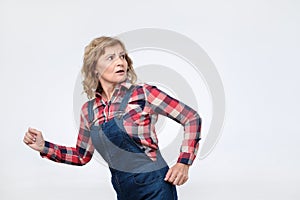 Scared mature woman running away isolated on white background.