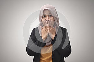 Scared muslim business woman keeping silence. Shocked young Asian woman in formal wear covering mouth by hands. Business and