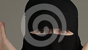 Scared muslim woman in niqab opens hers face