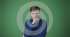 Scared and nervous man over green background