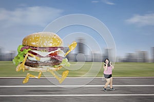 Scared obese woman escapes from a hamburger