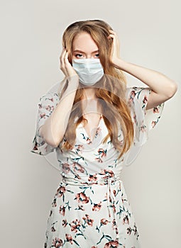 Scared panicking woman wearing a face mask on white background. Flu epidemic and covid-19 concept