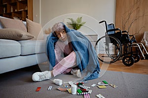 Scared senior woman with mental disorder wrapped in blanket