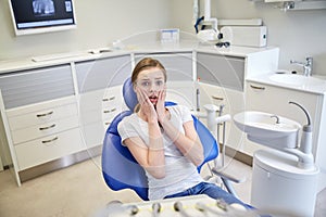 Scared and terrified patient girl at dental clinic