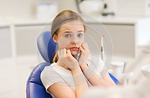 Scared and terrified patient girl at dental clinic
