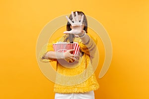 Scared woman in 3d imax glasses closing screen by hand, watching movie film, holding popcorn, plastic cup of cola or