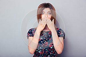 Scared woman covering her lips