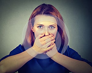 Scared woman covering her mouth with hands