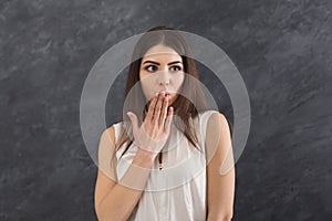 Scared woman covering mouth with hand