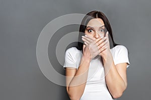 Scared woman covering mouth with hands