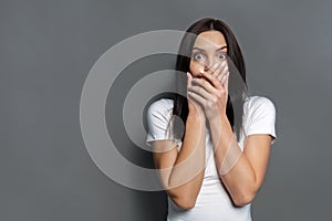 Scared woman covering mouth with hands